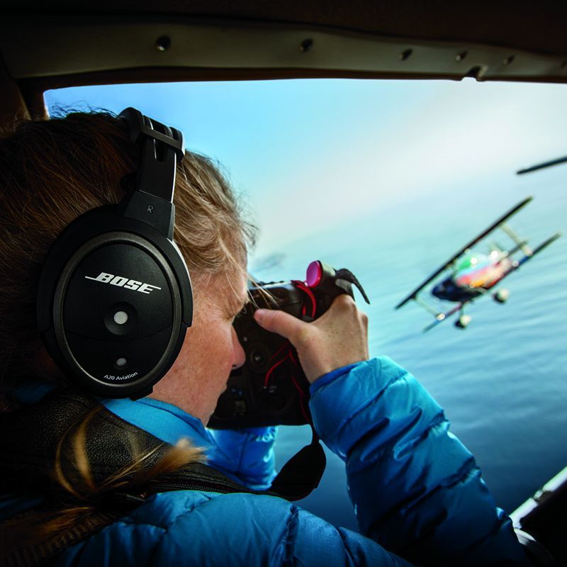 Pilot med Bose A20 flyheadset fotograferer et flygende dobbeltdekkerfly