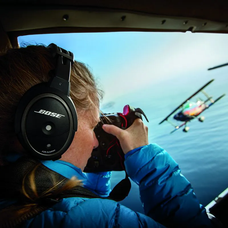 Pilot med Bose A20 flyheadset fotograferer et flygende dobbeltdekkerfly